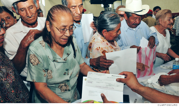 Fotografía de adultos mayores recibiendo apoyo de los programas sociales