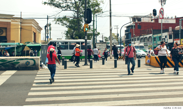 Personas atravesando un cruce peatonal durante el semáforo en rojo