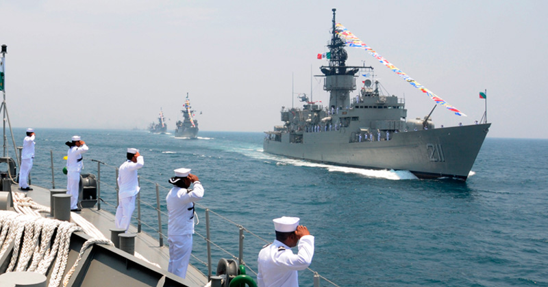 Imagen de marinos sobre un buque saludando a barcos